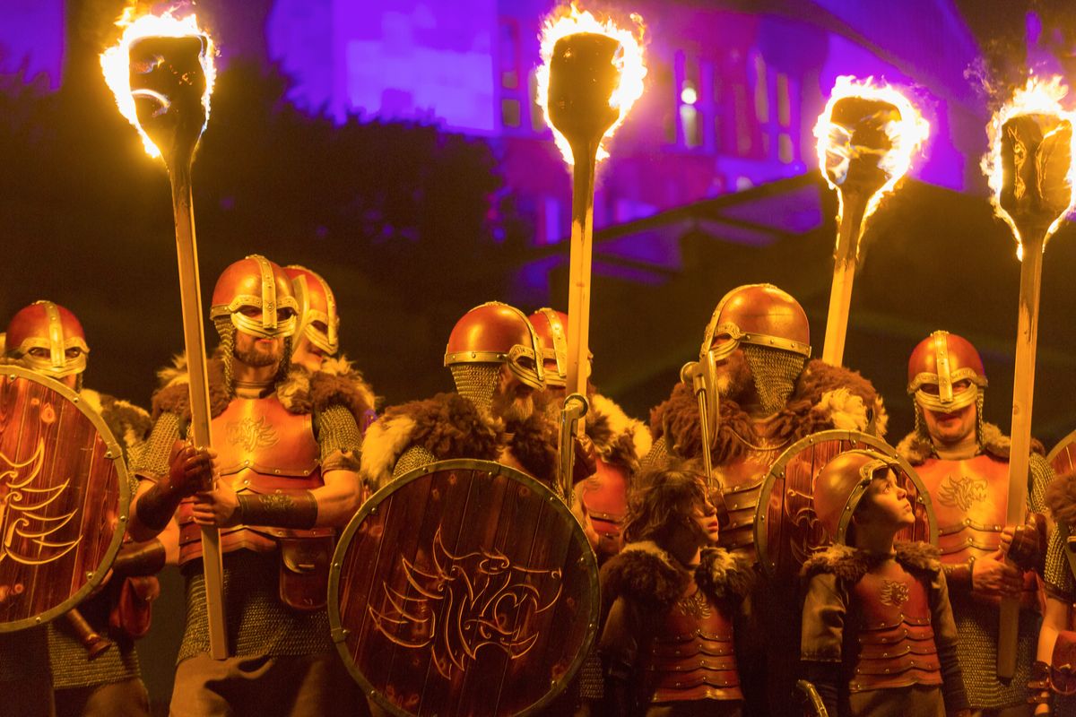 A group of people in armour holding torches