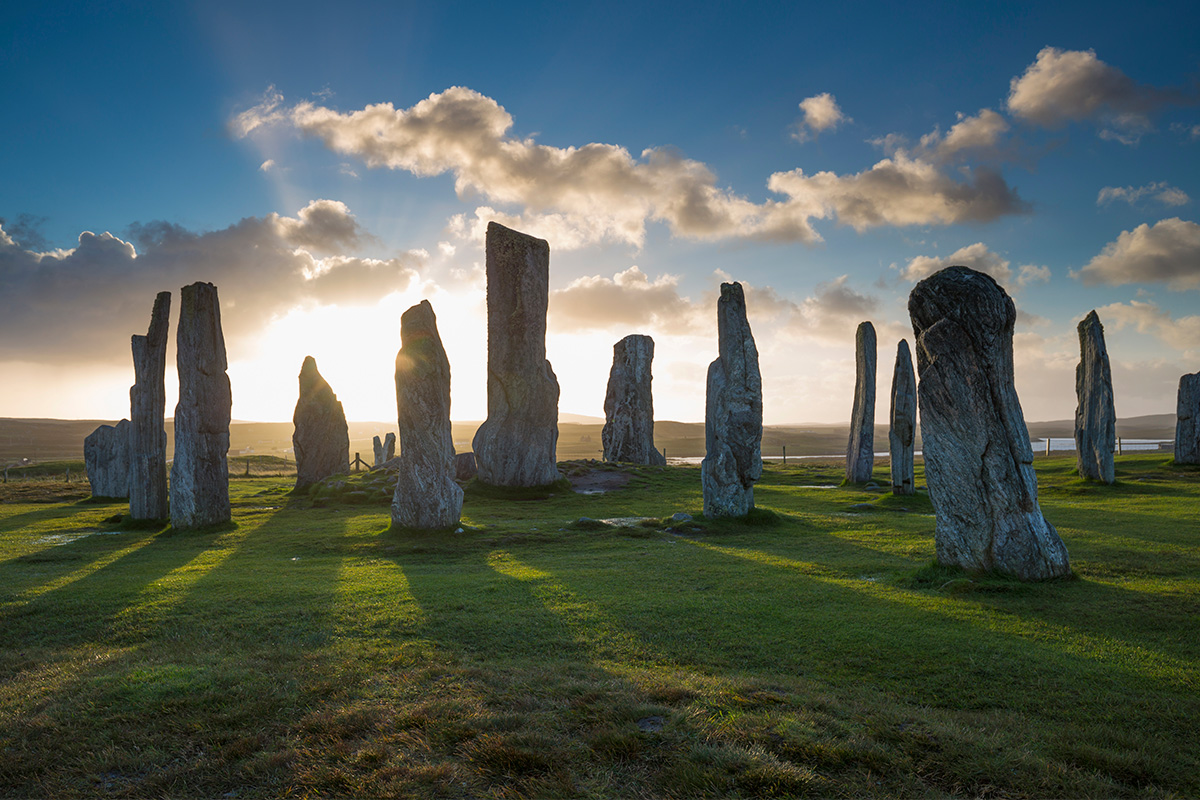 Standing stones against sunlight breaking through clouds