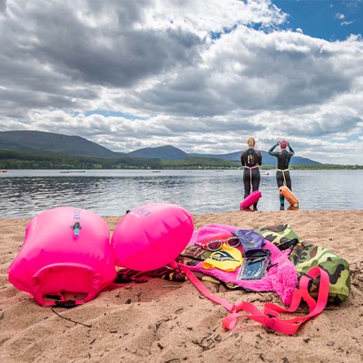 two people getting ready to go for a wild swim, with equipment in the foreground