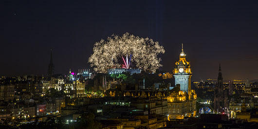 Fireworks going off over a city scape at night