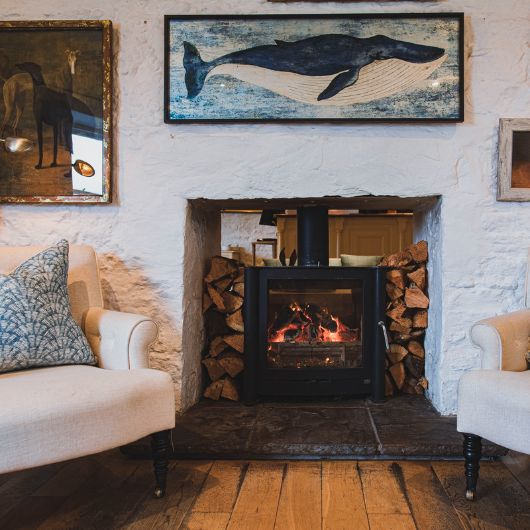 A fireplace with a picture of a whale and a painting on the wall